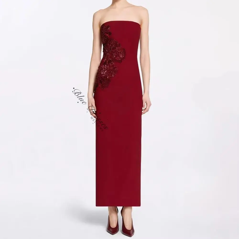 customized Burgundy strapless long gown with front floral ornament. Figure-hugging cut presents grace, elegant design embodies n