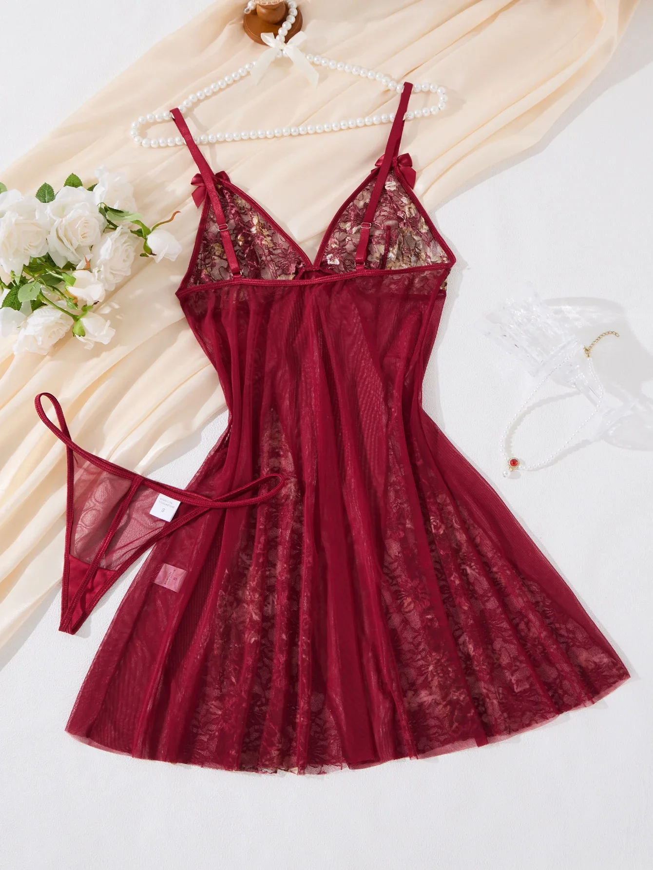 빨간색 섹시한 잠옷, 매혹적인 매력을 발산하며, 일상적인 가정 생활에 매력적인 터치를 더해주는 오픈워크와 레이스 트리밍이 특징입니다.