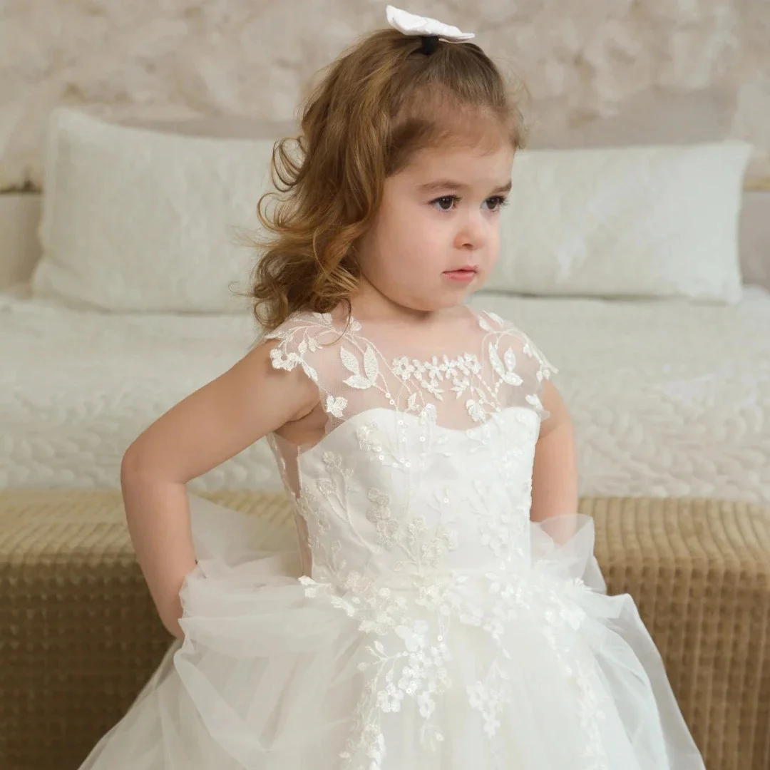فستان فتاة الزهور البيضاء المخصص من التول مزين بالزهور مع فيونكة بدون أكمام لحفلات الزفاف وأعياد الميلاد وحفلات التواصل المقدس