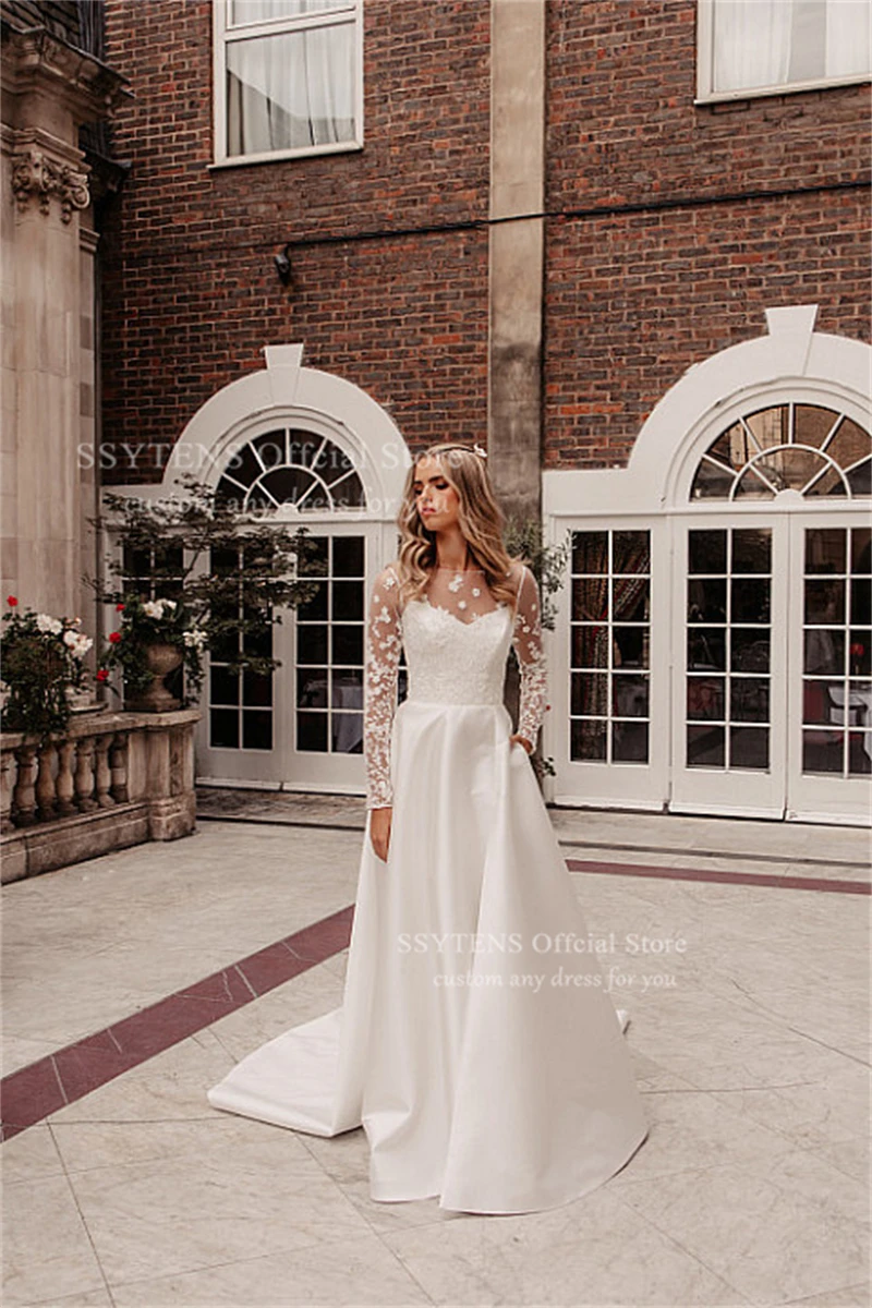 ชุดแต่งงานทรงเอไลน์สุดหรูจาก SSYTENS สีขาว ประดับด้วยลูกไม้ แขนยาวแบบซีทรู  ชุดเจ้าสาวแบบคอร์เซ็ทสั่งตัดได้ ปี 2026