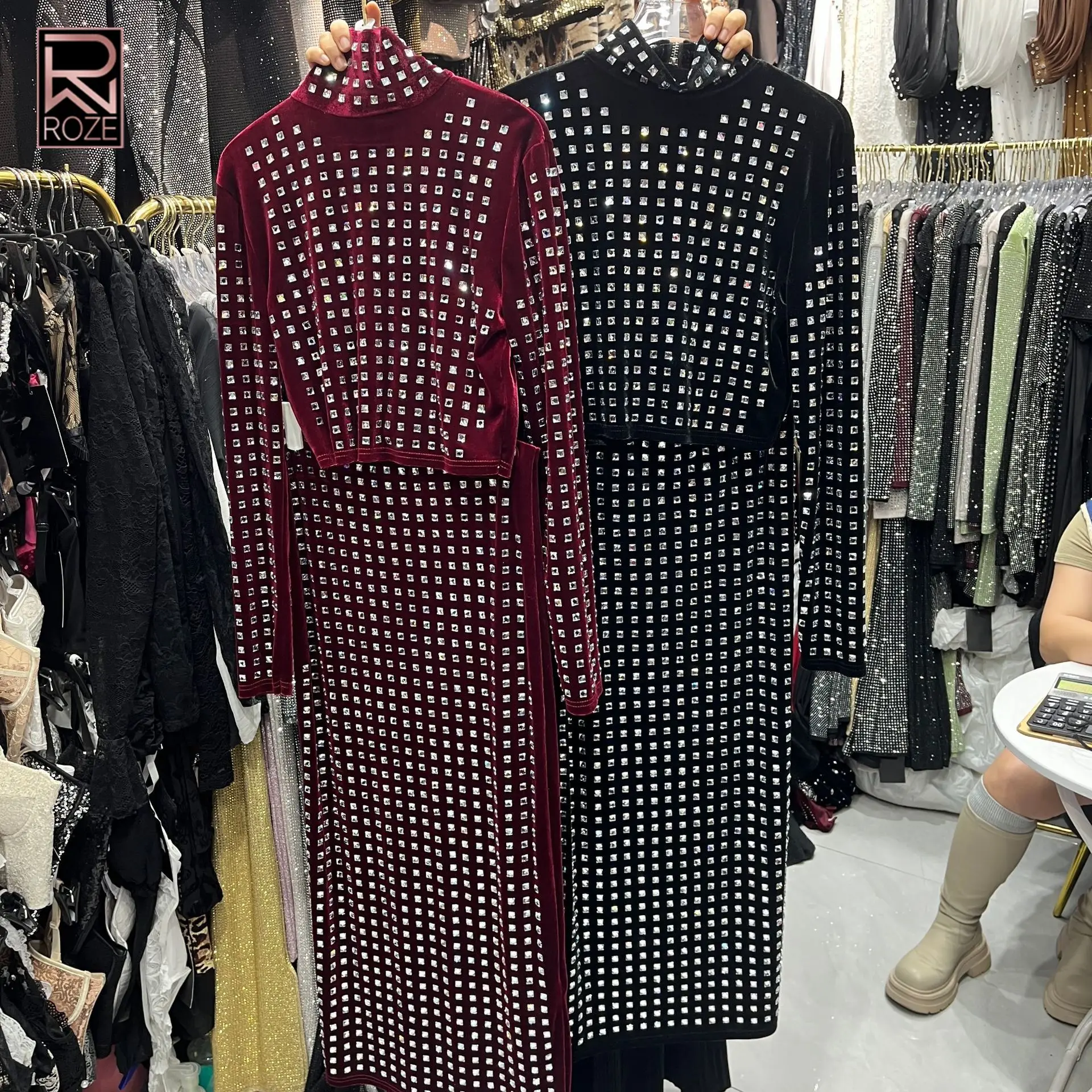 

Новый женский бархатный комплект из двух предметов 2026 года: укороченный топ с высоким воротником и длинными рукавами, украшенный квадратными стразами, и макси-юбка для вечеринок