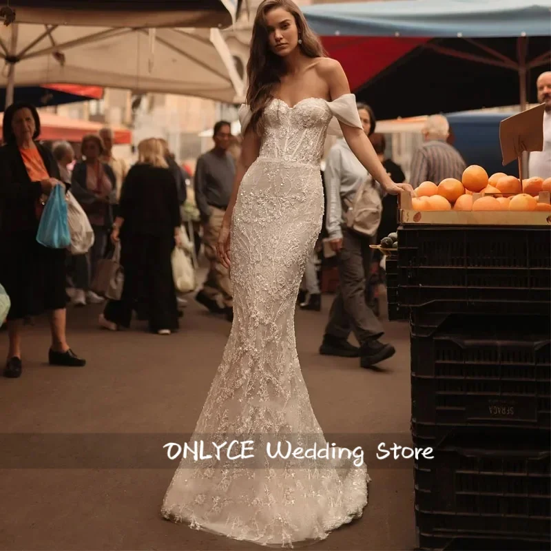 Suknia ślubna w stylu syreny, seksowna, pełna wdzięku, z dekoltem w serduszko, z tiulu w kolorze ecru, z odpinanym trenem.