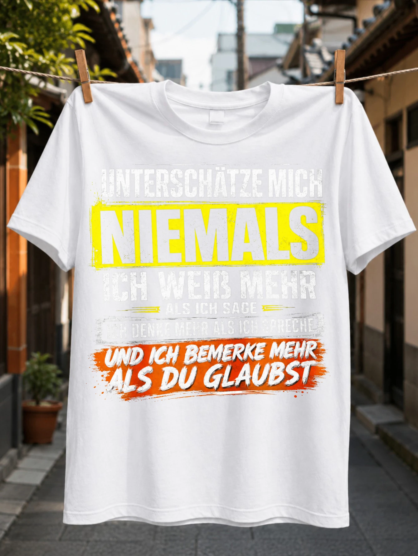 T-shirt unisexe jaune vieilli avec la citation « Never Underestimate Me » en lettres majuscules et citation d'optimisme humoristique