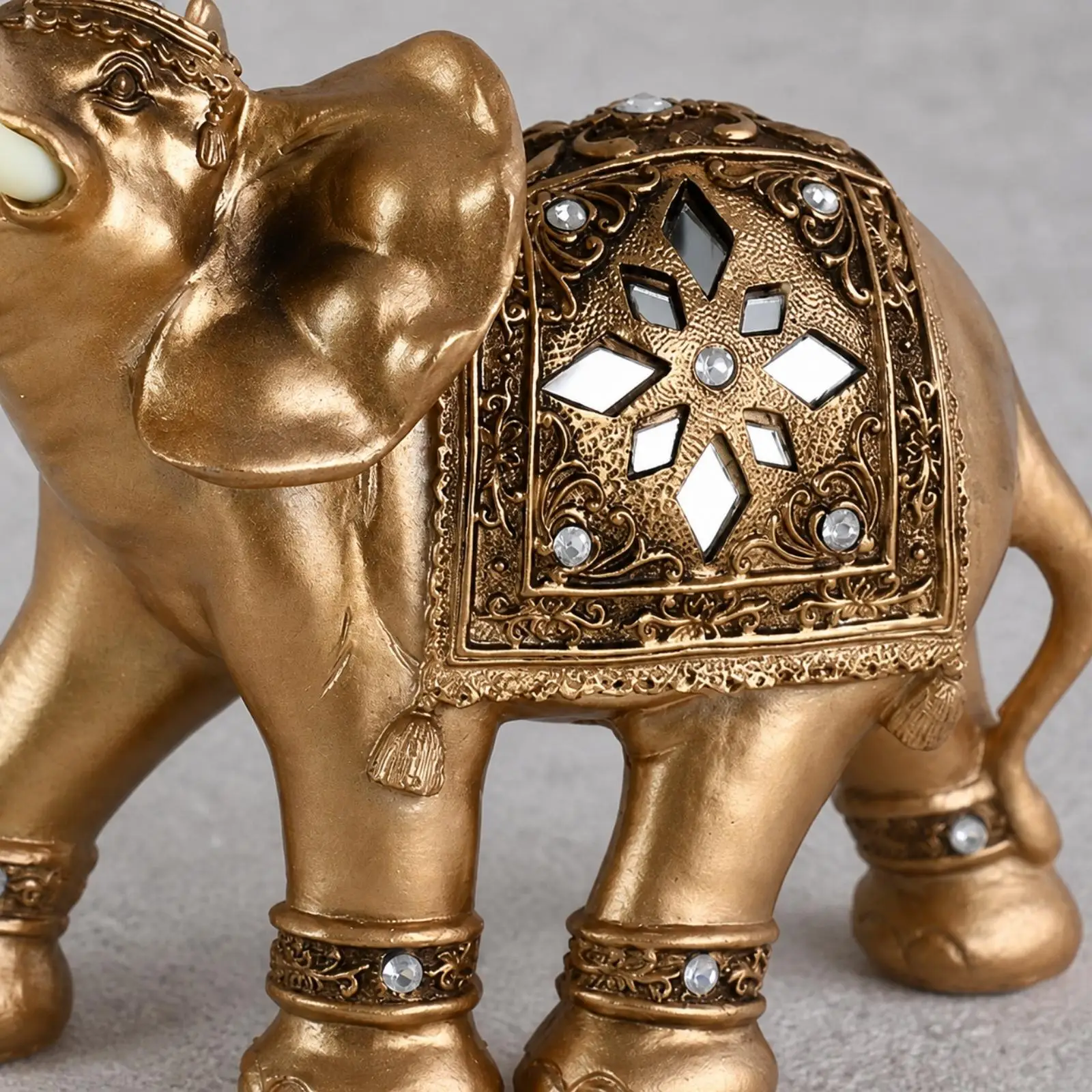 Raised Trunk Elephant Statue Synthetic Resin Decorative Craft with Ivory Tusks and Intricate Saddle Design for Bookshelf Accent
