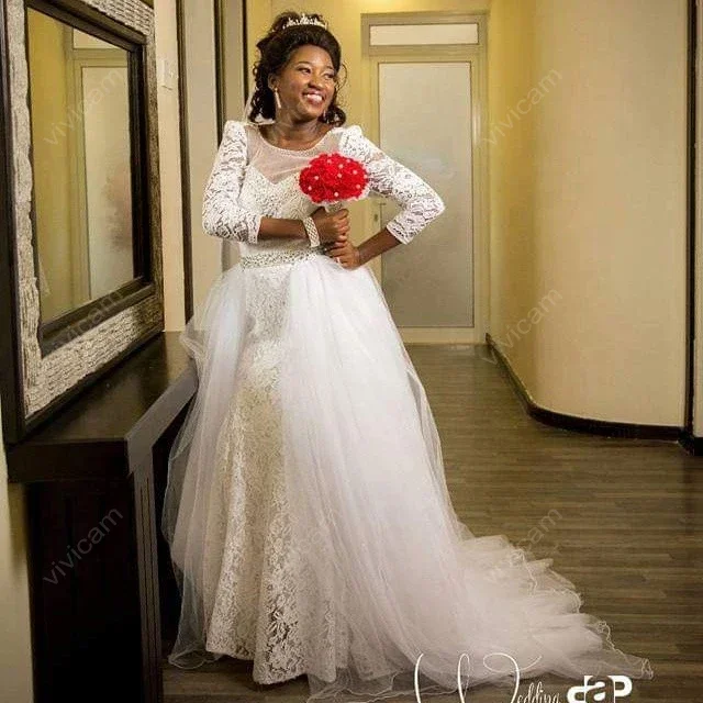 Suknie ślubne z koronką, dekoltem w łódkę, długimi rękawami, odpinanym trenem i odkrytymi plecami, zdobione uroczy, personalizowane kryształki.