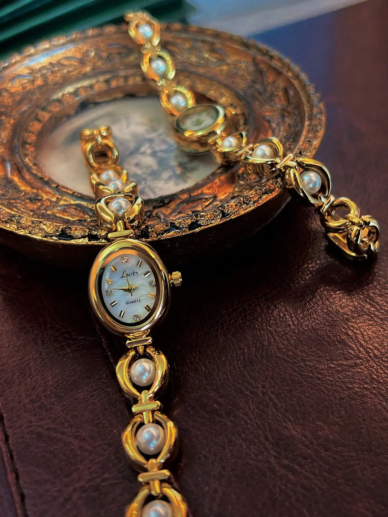 

Элегантные овальные кварцевые часы с золотистым ремешком, украшенным жемчугом, для повседневного ношения.