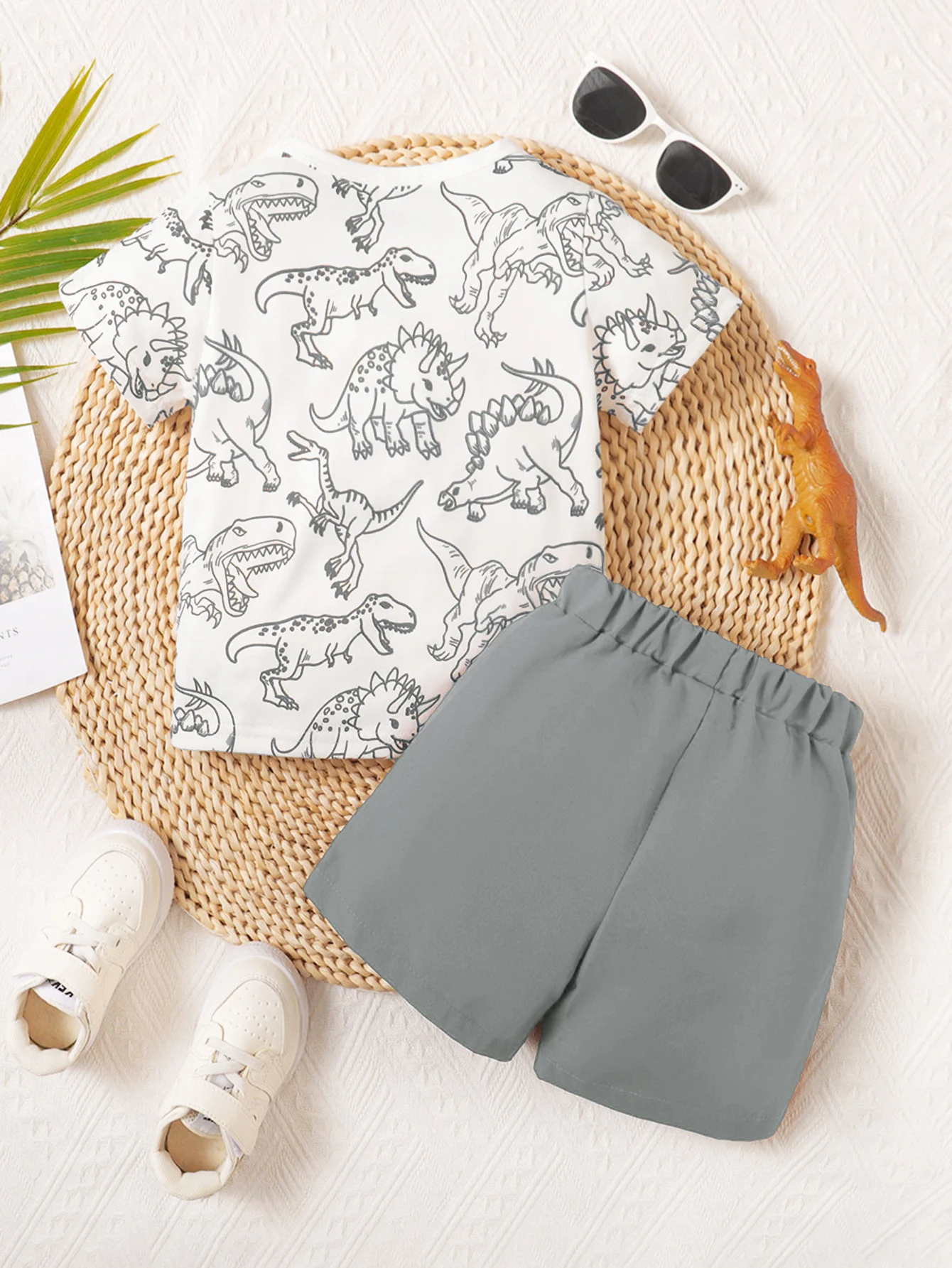 Fun Hand-Painted Dinosaur Print Boys' Summer Two-Piece Set, Featuring a Round-Neck Short-Sleeve Top with Decorative Pockets Paired with Gray Shorts, Made of Soft Fabric, Suitable for Children's Summer Outfits for Everyday Outings