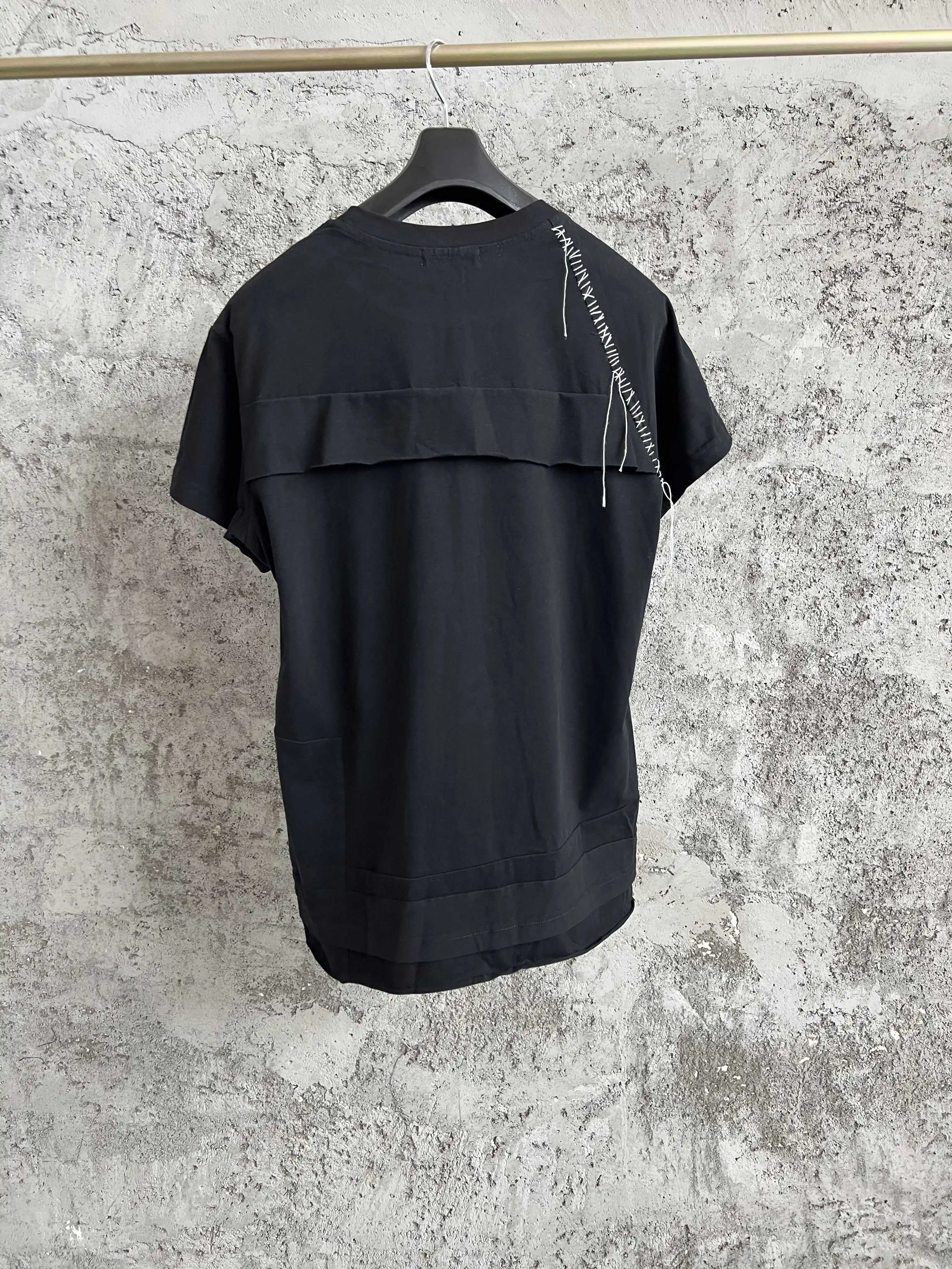 

A short-sleeved black irregularly pieced back design top with a loose round neck and versatile T-shirt