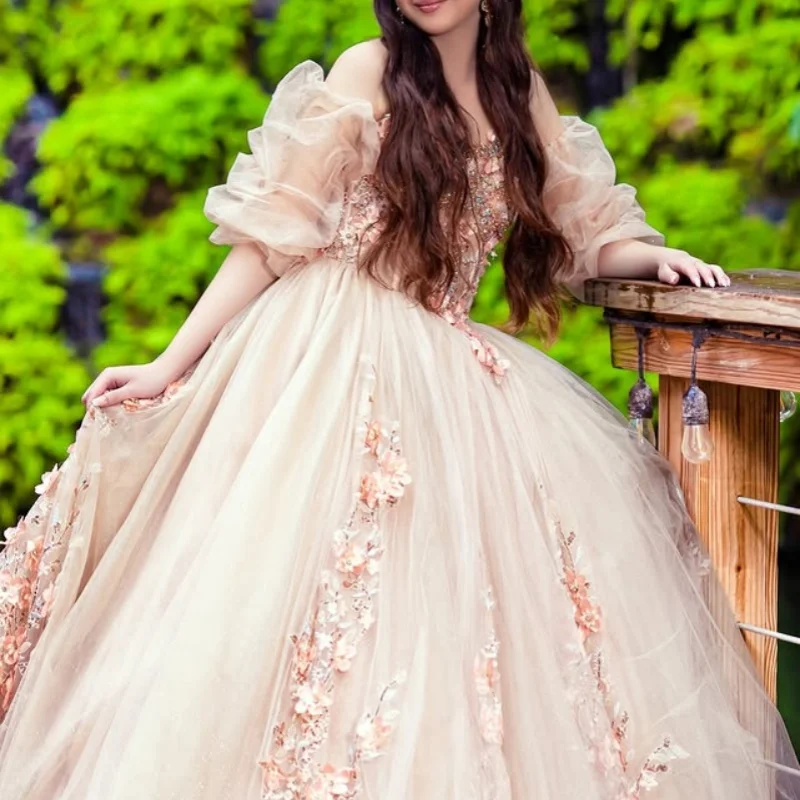 ชุดเดรสงาน Quinceanera สีแชมเปญอ่อน ประดับคริสตัลวิบวับ ลายดอกไม้ 3 มิติ พร้อมชายกระโปรงยาว ﻿ ปรับแต่ง