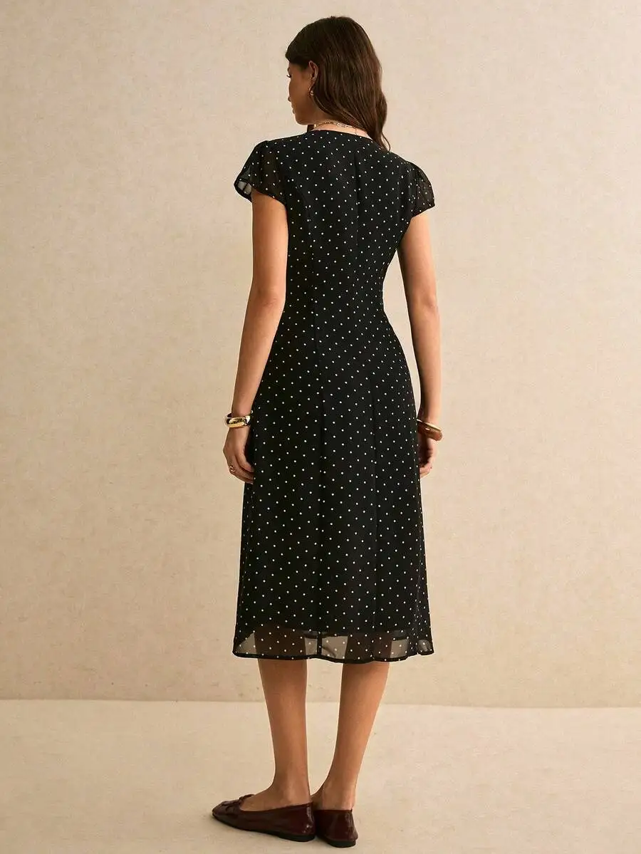 

Black Polka Dot Midi Dress With V-Neck, Button-Front Closure, Sheer Puffed Cap Sleeves, And High Side Split For Retro Summer