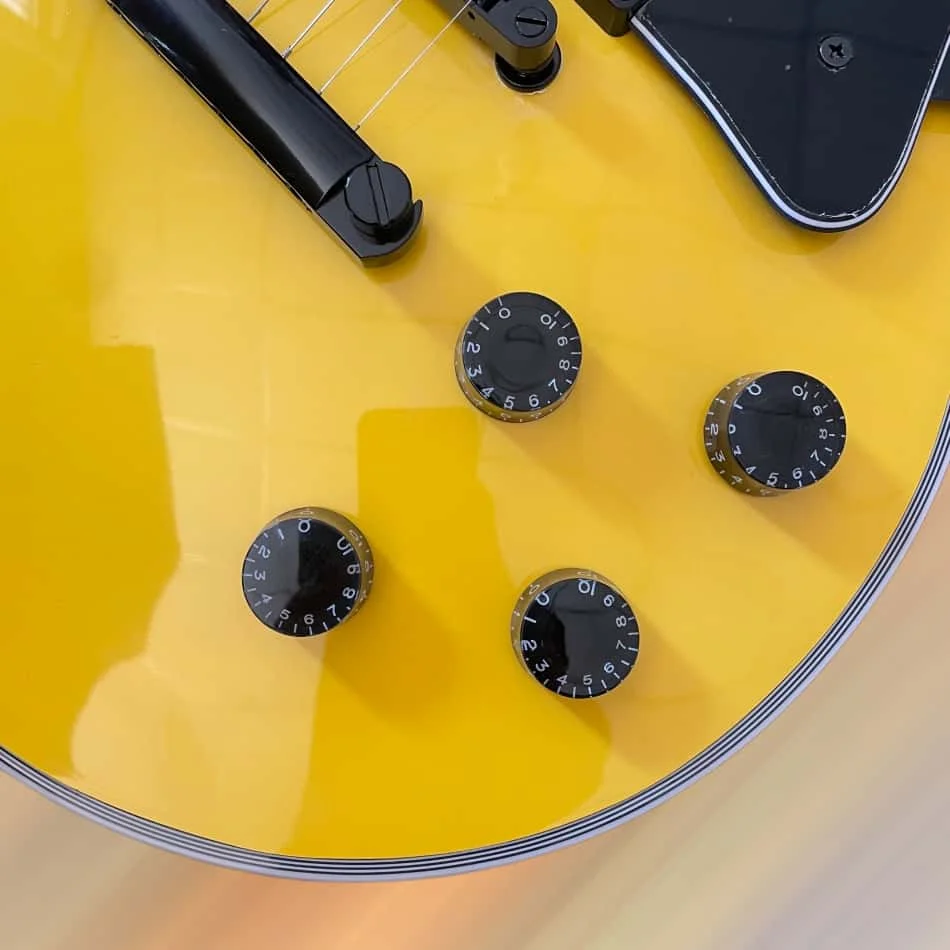 Yellow 6-string electric guitar with black hardware, rosewood fingerboard, and mahogany body