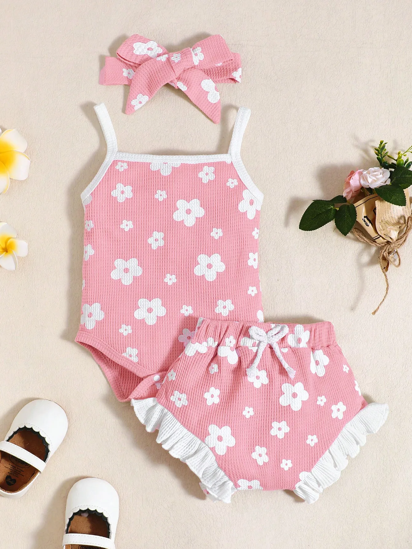 Sweet Summer Three-Piece Set for Baby Girls, Featuring a Pink Waffle-Patterned Romper with Fresh White Floral Print, Paired with Ruffled Floral Shorts and a Matching Fabric Bow Headband. the Cute Design Is Perfect for Infants and Toddlers to Wear on Daily Outings, Vacations, and Playtime.