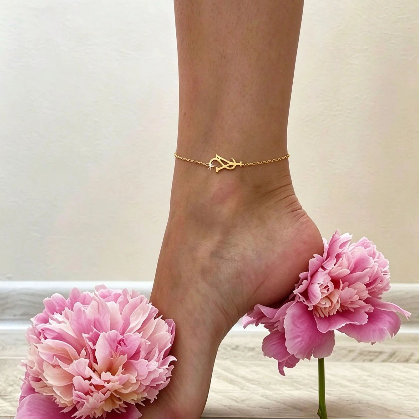 Stylish, minimalist, and sexy vacation-style stainless steel anklet for women, plated in 18K gold and featuring letter detailing