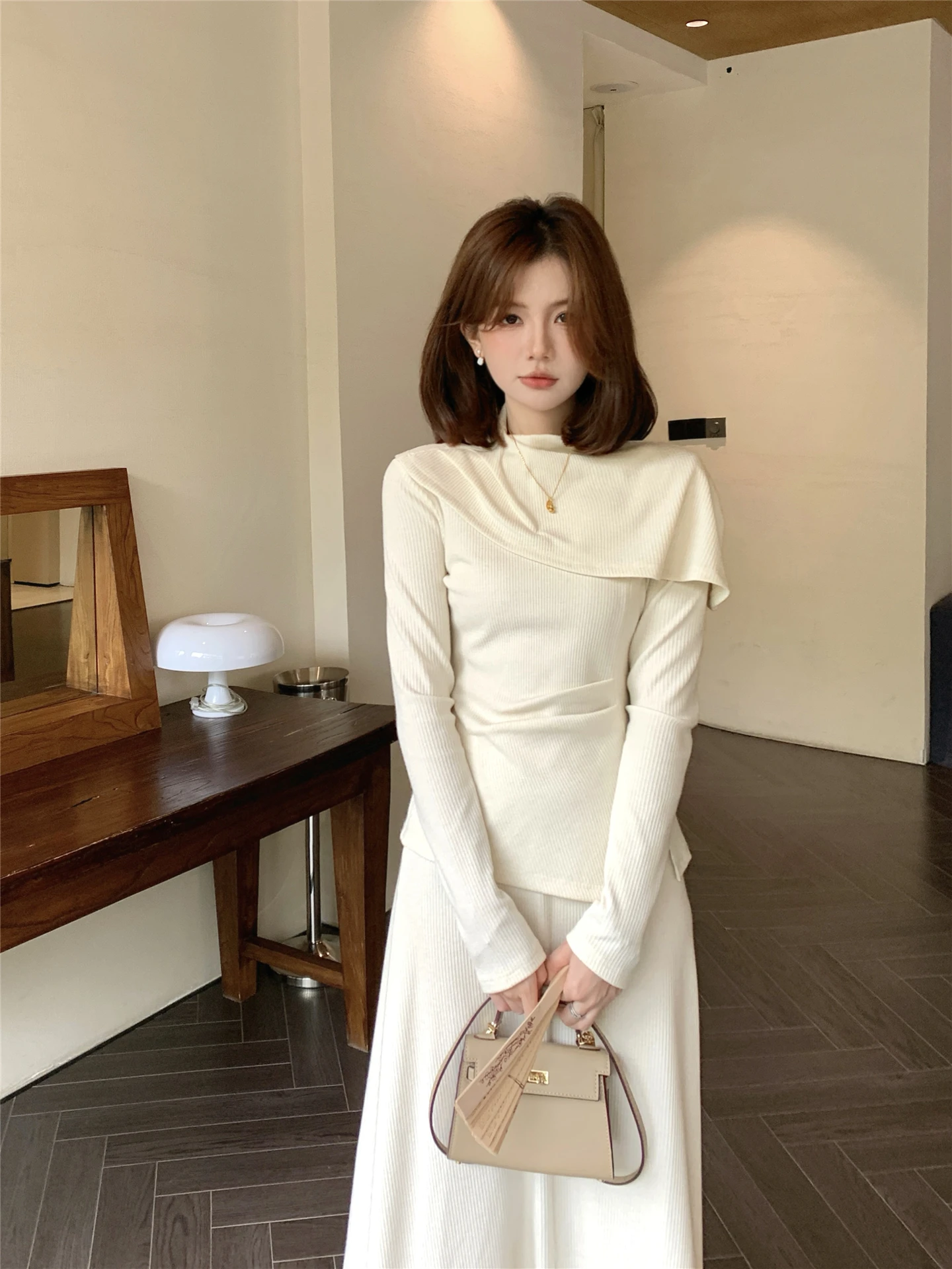 

Корейский модный осенний комплект из двух предметов: юбка с высокой талией и топ с длинными рукавами. Элегантный повседневный ансамбль.