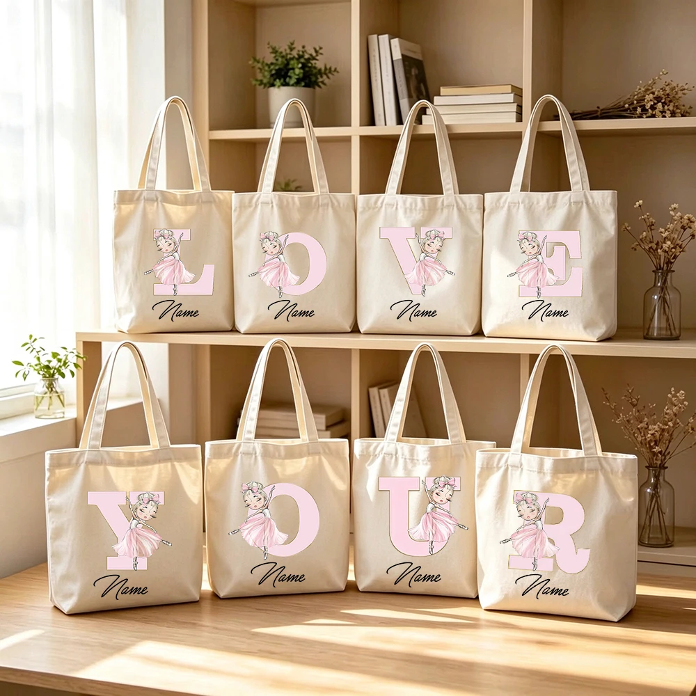 Bolsa de lona personalizada con la inicial de un nombre, ideal para llevar en la mano, con un diseño de bailarina rosa y letras, perfecta para ir de compras o llevar la compra, reutilizable y un regalo ideal para niñas.