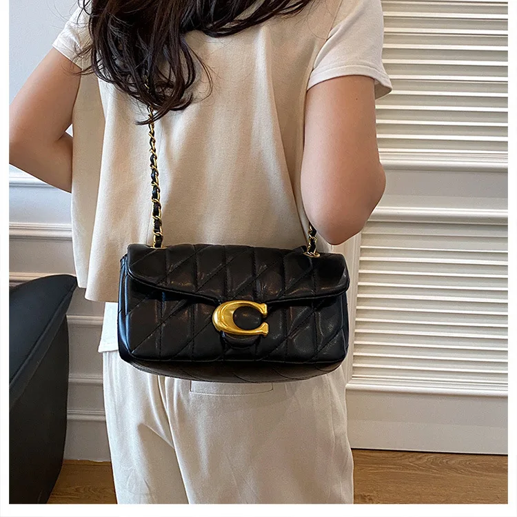 un-pequeno-bolso-cuadrado-de-cuero-con-diseno-de-diamantes-muy-bien-elaborado-y-una-bandolera