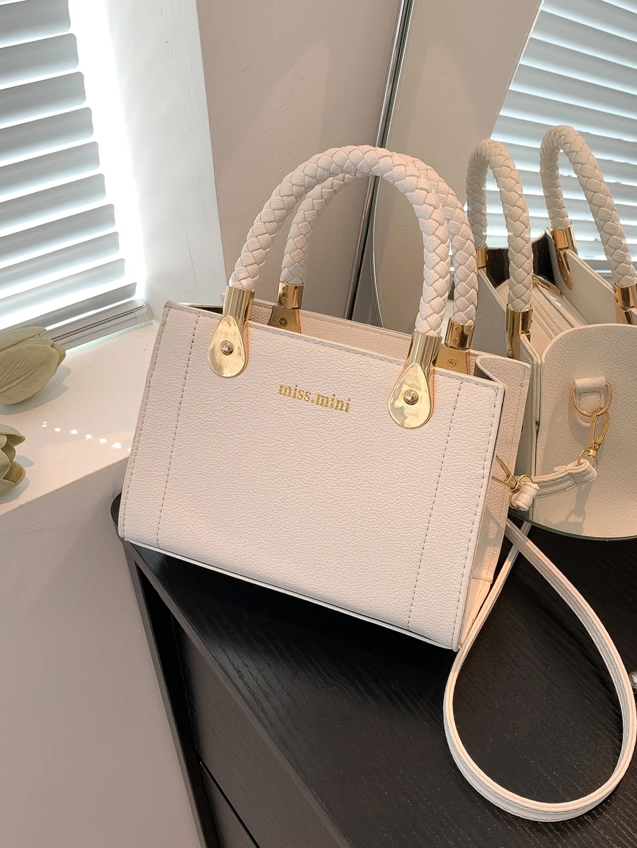 

Белая текстурированная сумка с верхней ручкой, плетеным ремешком и золотистой фурнитурой