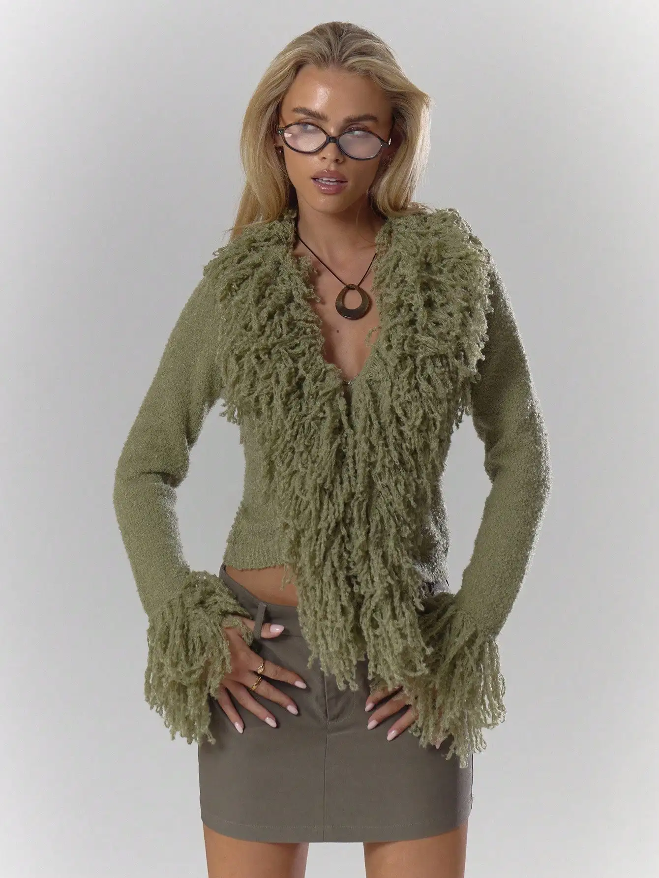 Kardigan w kolorze oliwkowej zieleni z puszystym wykończeniem i rękawami z frędzlami, idealny na jesień i zimę, zapewniający elegancję na co dzień.