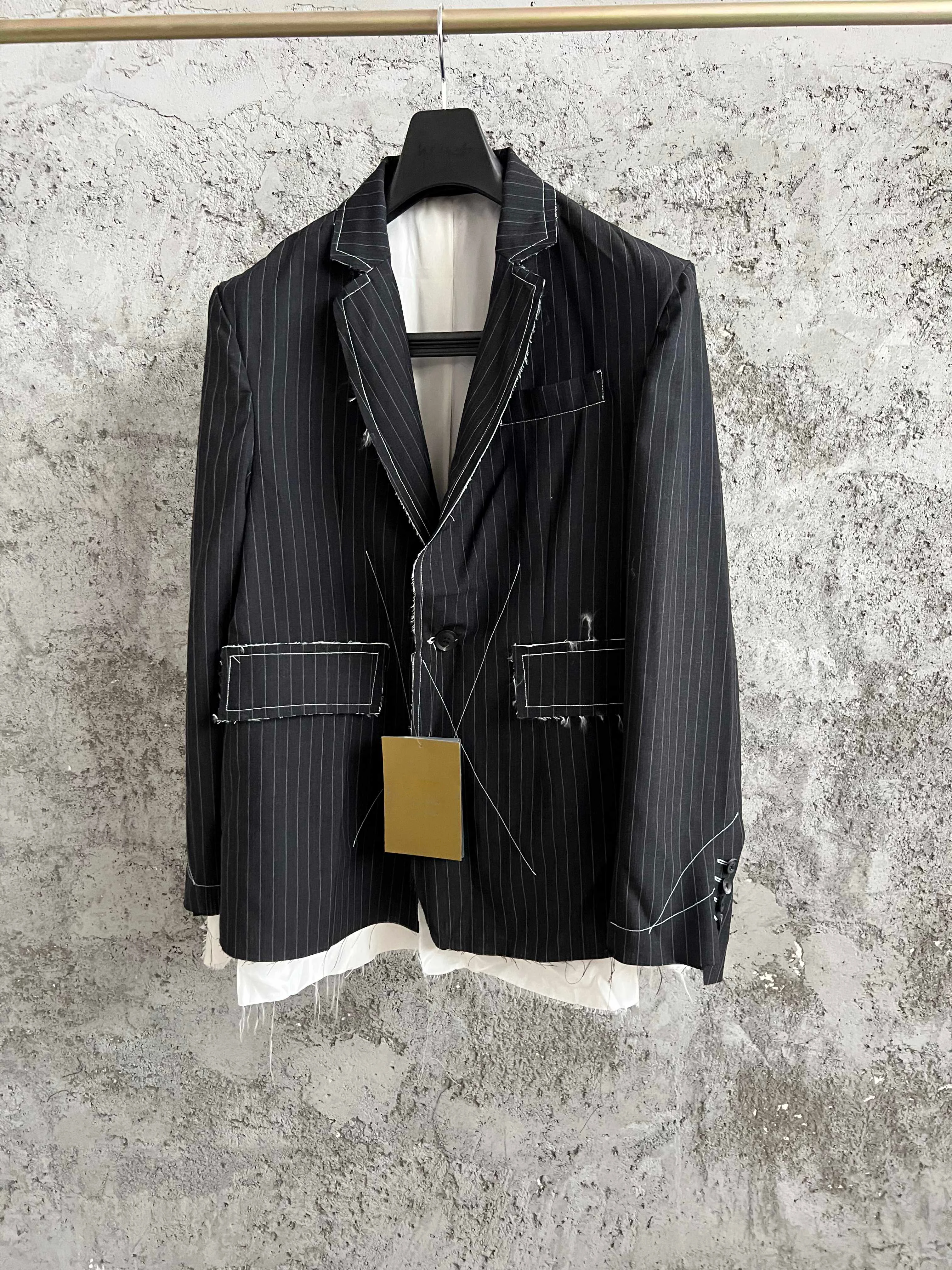 

TOP-YAMAMOTO deconstructs black and white striped wool suits with fringed and flowing lines, a niche brand