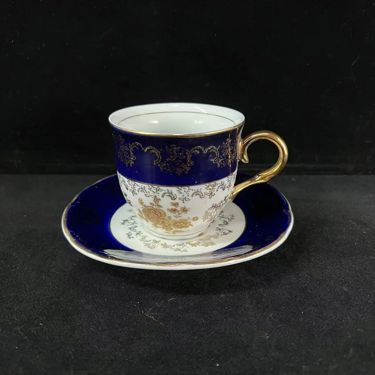 Vintage cobalt blue glazed ceramic coffee cups and plates with gold embossed European gold rimmed coffee utensils