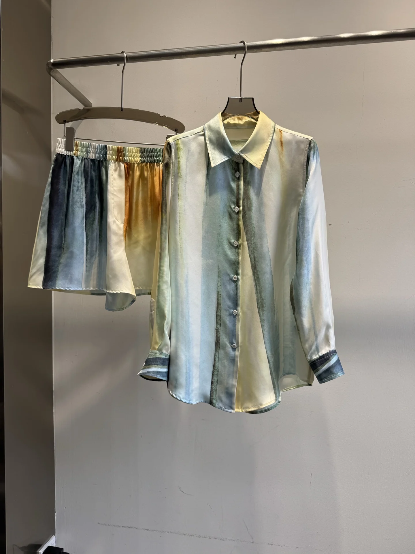 Women'S Vintage-Style Silk Shirt Featuring An Ink-Wash Or Oil-Painting-Inspired Watercolor Print, Paired With Casual Shorts.