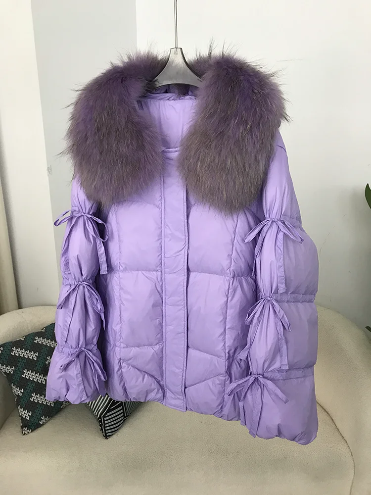2025 الشتاء النساء بطة أسفل سترة معطف سوبر كبير ريال الراكون الفراء طوق مع ربطة القوس فيونكة كم موضة ملابس خارجية فاخرة