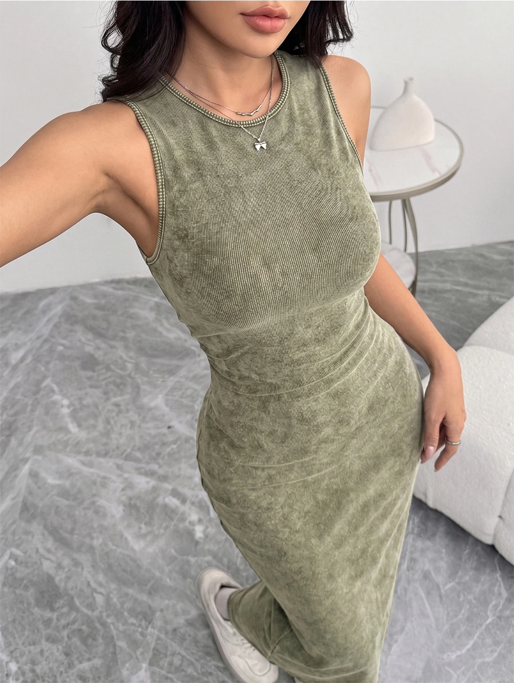 Robe moulante élégante à col rond et sans manches, avec un effet délavé et usé.