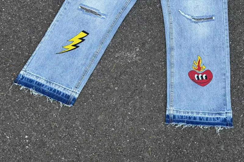 เย็บปักถักร้อยการรับรู้ปลอมเพชรการ์ตูน Graffiti กางเกงยีนส์ผู้ชายผู้หญิงคุณภาพสูง Hip Hop เสียหลวมตรงกางเกงยีนส์