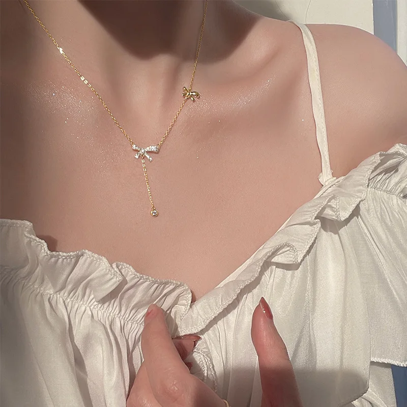 Bow-shaped pendant necklace crafted from 925 silver with copper clavicle chain — minimalist yet refined, elegant tassel detail,