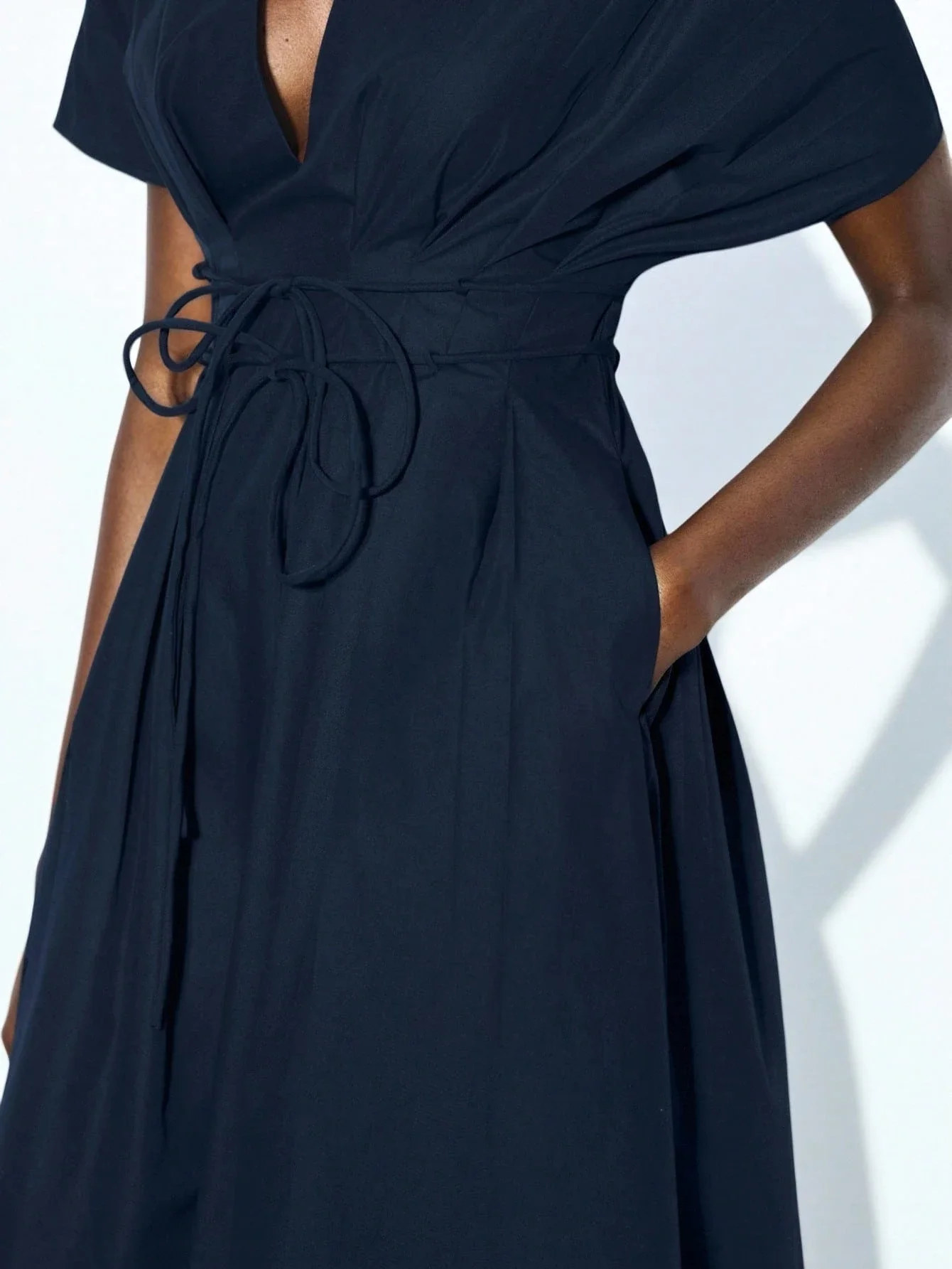 

Темно-синее платье миди с глубоким V-образным вырезом, пышными рукавами, завышенной талией и расклешенным А-образным подолом