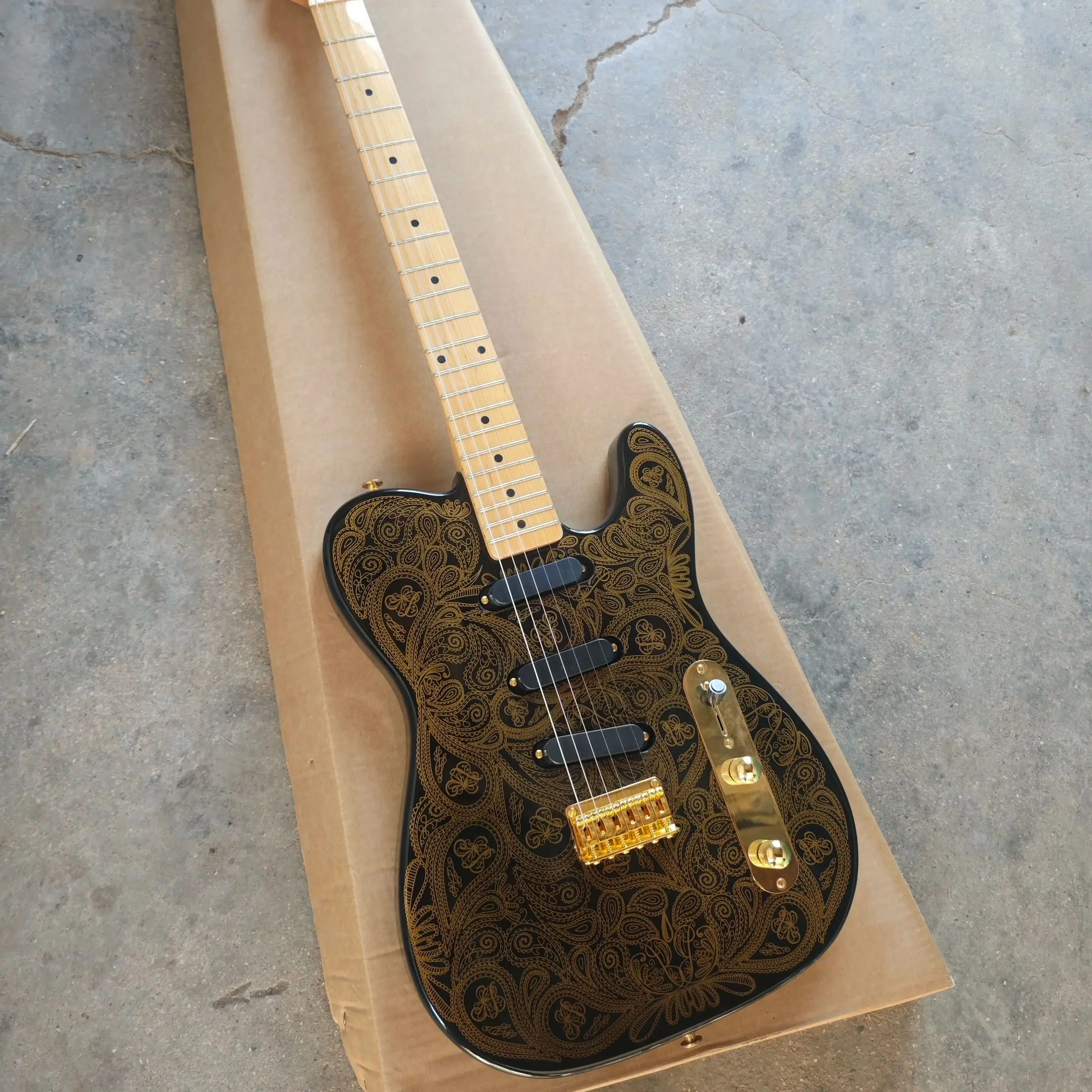 

Black six-string electric guitar, gold printed basswood body, maple neck and maple fingerboard with gold hardware.