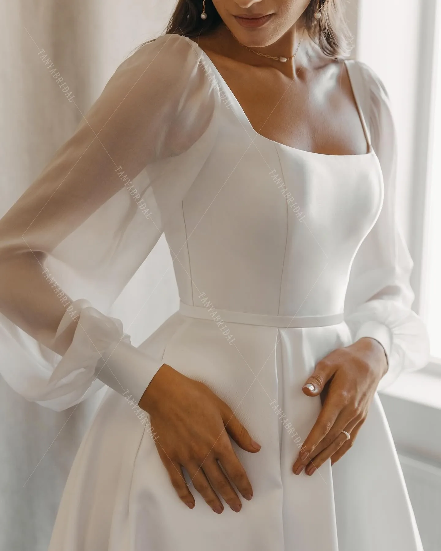 ชุดแต่งงานผ้าซาตินคอเหลี่ยม แขนยาว ทรงเอ ผ่าข้างสูง ชายกระโปรงยาวลากพื้น ดีไซน์หรูหรา