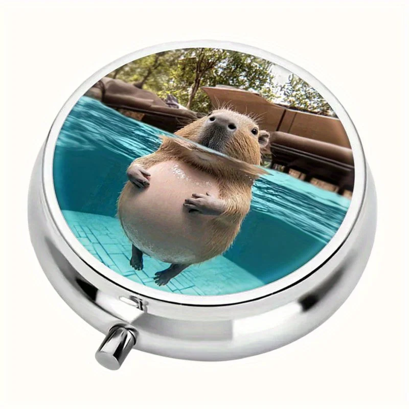 A round pill box in the shape of a capybara swimming in a pool, featuring three compartments and a fun animal-themed design, is convenient to carry in a handbag and makes a fun gift for animal lovers
