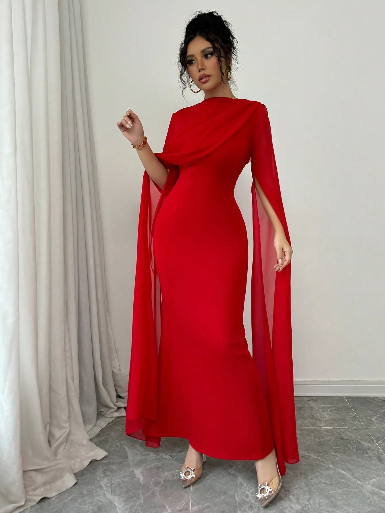 Robe longue asymétrique rouge avec manches cape transparentes et détails plissés