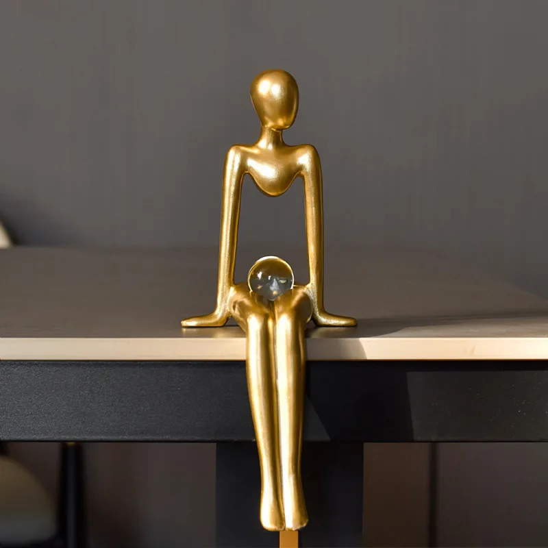 Simple little golden man holding a ball and listening to music, gold abstract figure sculpture home decoration office