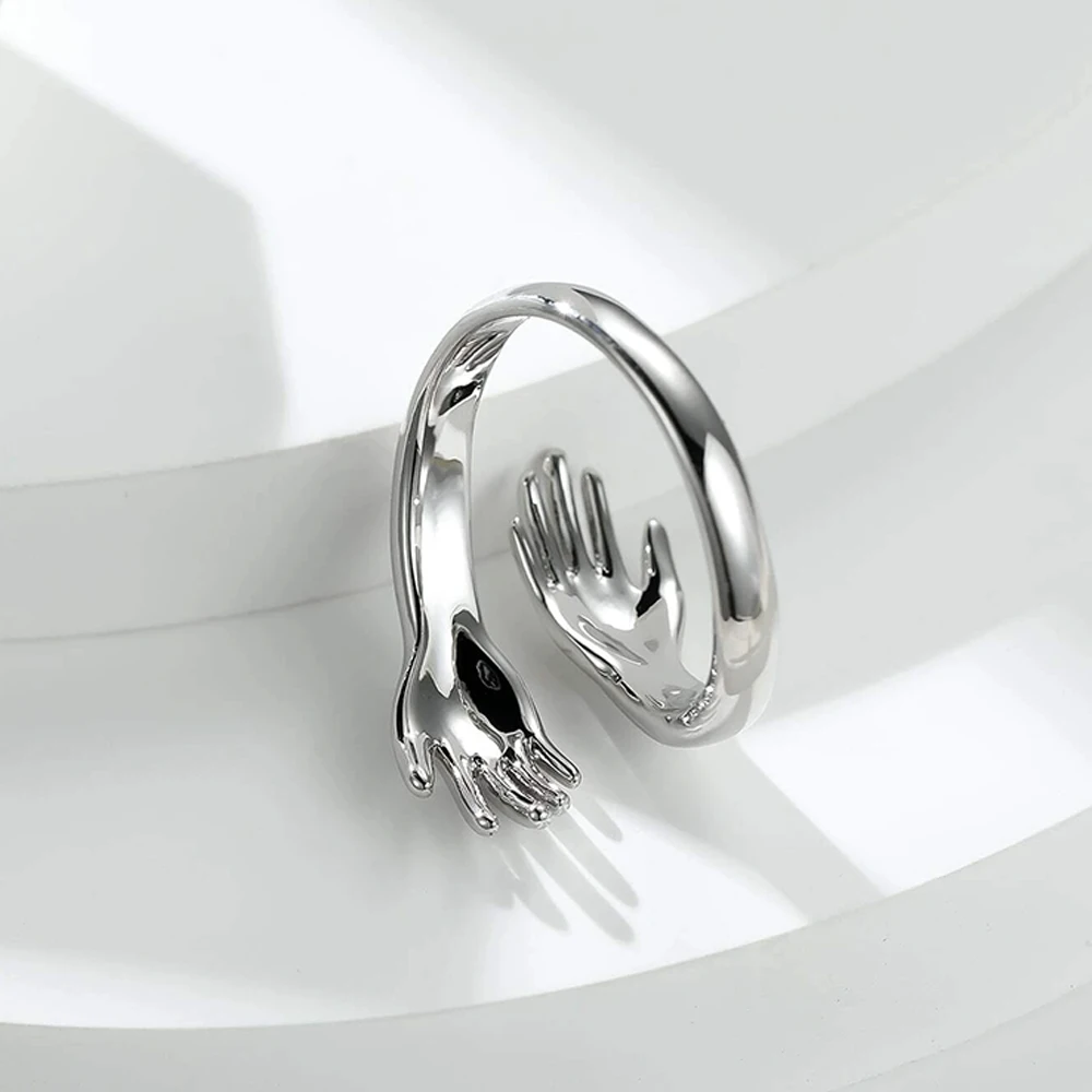 خاتم عناق عصري ثلاثي الأبعاد، لون ذهبي مع تصميم متشابك لليدين، تفاصيل رائعة وملمس كامل، مناسب للارتداء اليومي