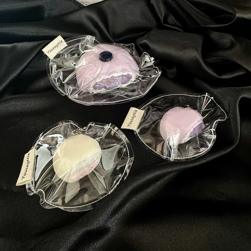 Dos tipos de juguetes mochi de rebote lento y textura suave con sabores realistas: mochi grandes y pequeños rellenos de arándanos, y pequeños mochi de fresa.