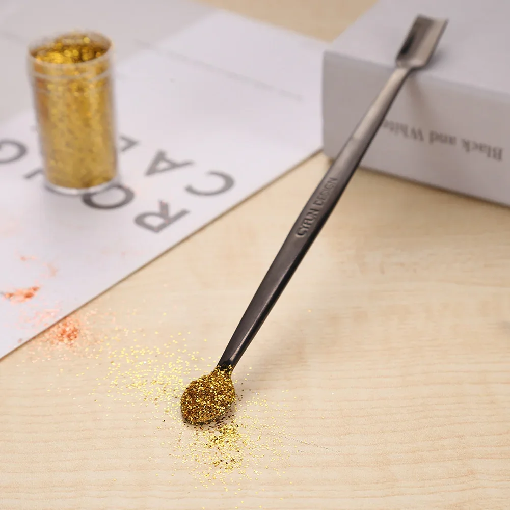Farben, Bastellöffel, die für die Arbeit mit glitzernden Prägungspulvern, Pailletten und anderen kleinen Verzierungen machen, Karten, Sammelalben