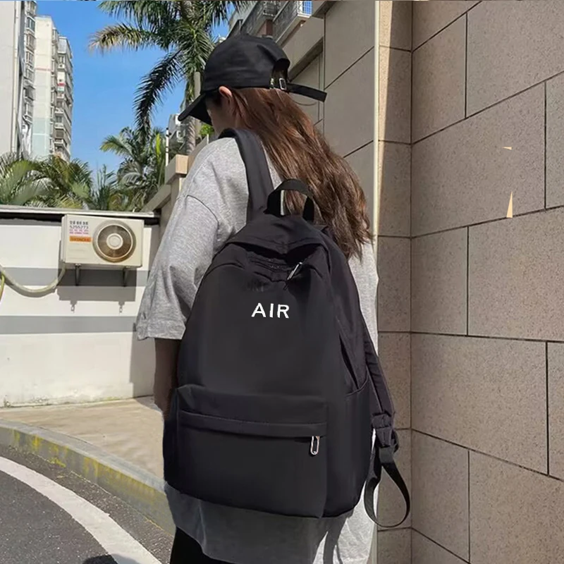 حقيبة ظهر ذات طراز محايد للرجال والنساء، مناسبة للسفر والاستخدام المدرسي. مع تصميم مطبوع عليه حروف.