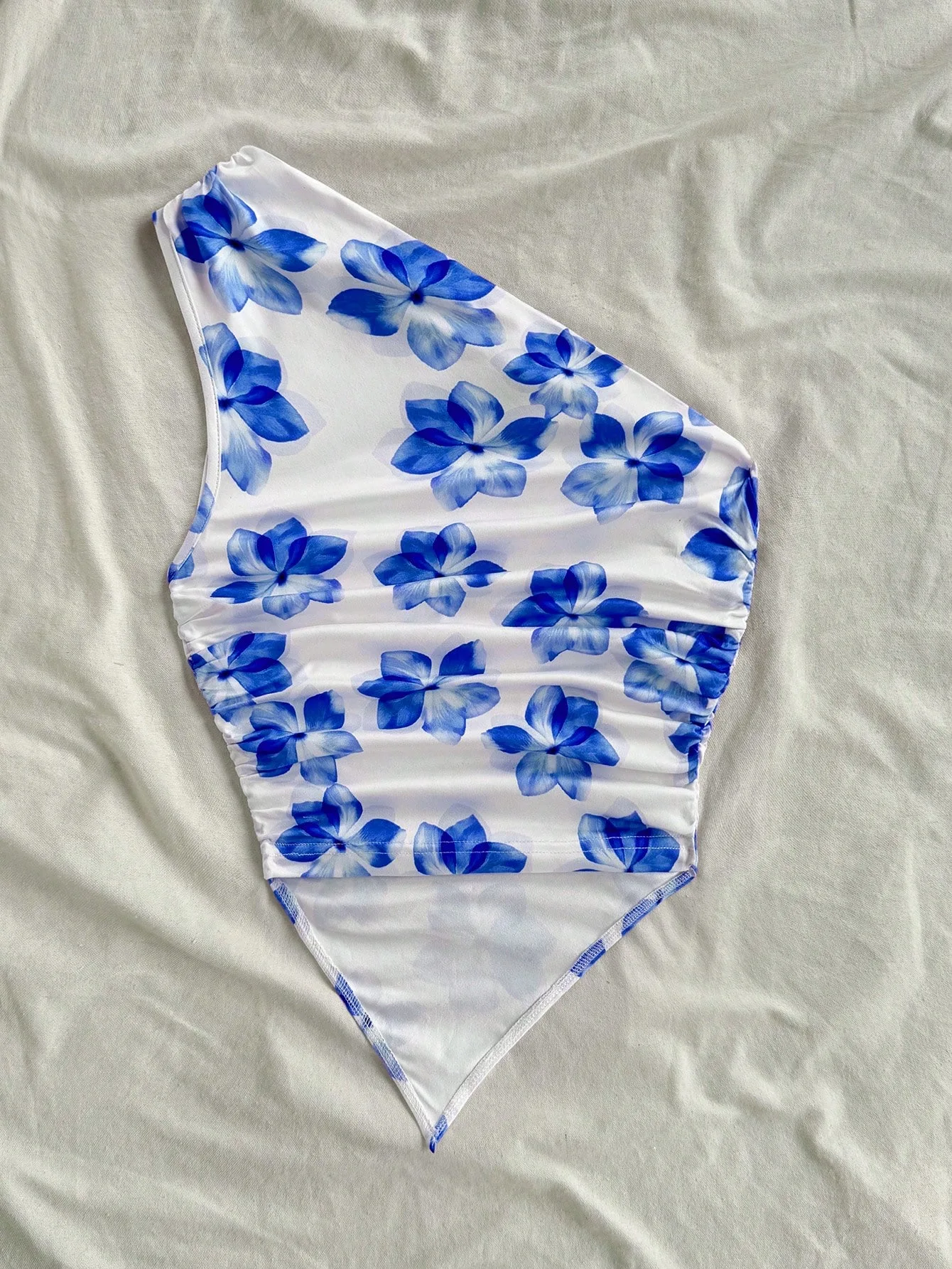 This Stylish Top Features Beautiful Floral Print, Trendy One-Shoulder Style and Delicate Ruched Details. The Asymmetric Hem Crea