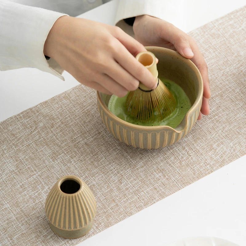 

Japanese Yadoya pottery set with a green tea bowl featuring a spout, a thick ceramic set of tea whisk, bamboo green tea brush.