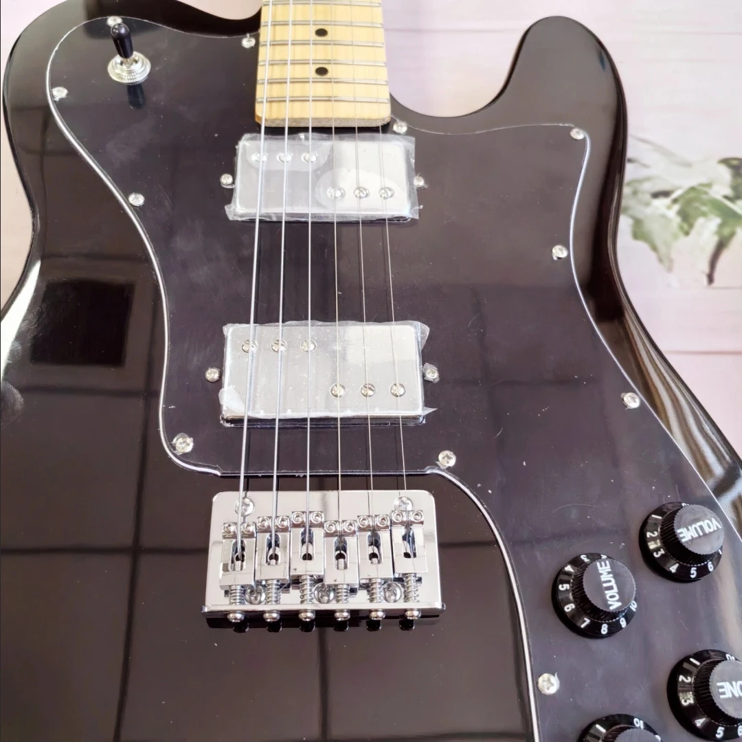 جيتار كهربائي أسود برقبة من خشب القيقب يتميز بلوحة واقية كبيرة وجسم ماهوجني قوي وجودة استثنائية