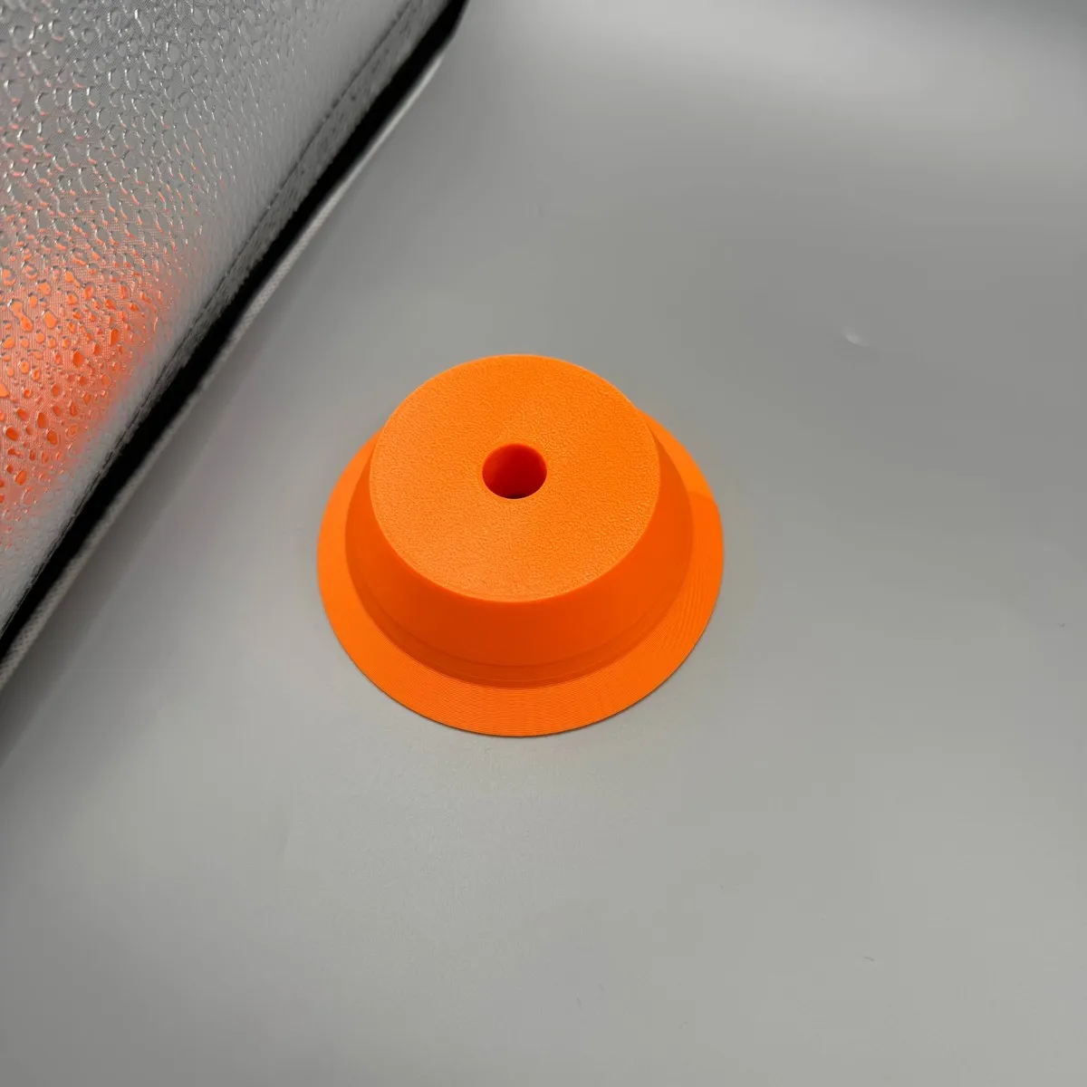 Circular electric drill dust collector with central guide hole, used as a dust shield for drilling holes in walls and ceilings