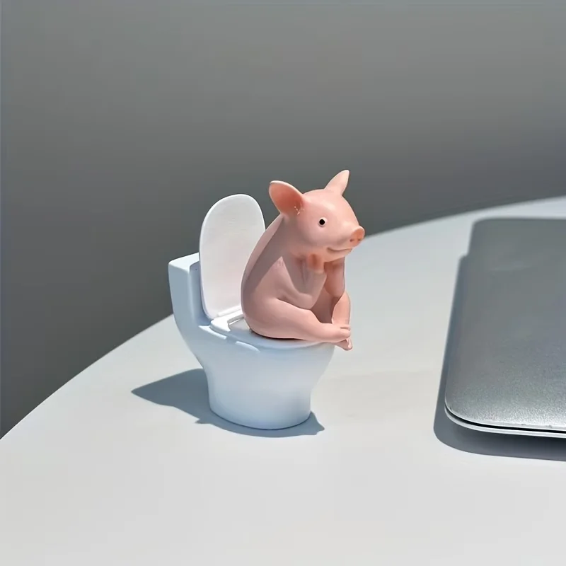 A Little Pig Figurine Sitting on the Toilet - A Decorative Item, Placed on the Table or Wall, on a Home Office Desk