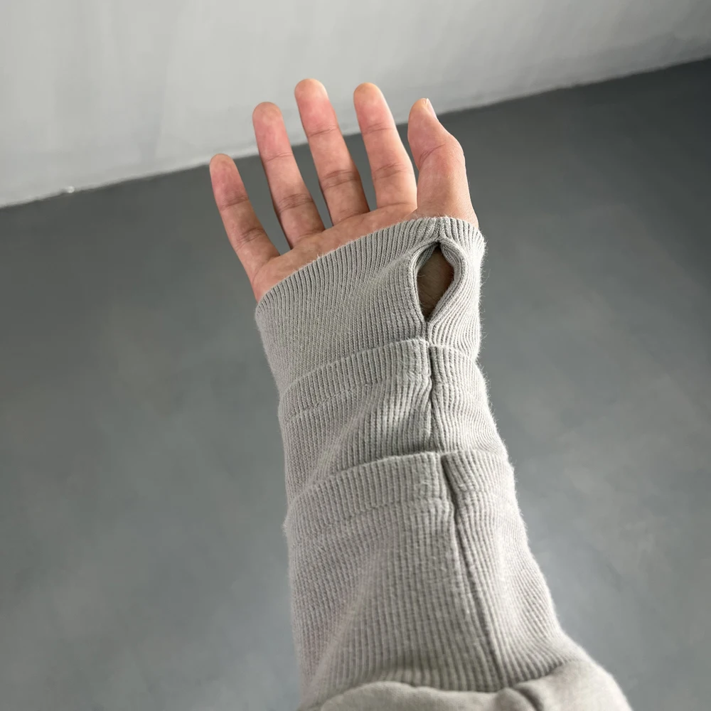 Overlapping three threaded cuffs with exposed finger holes frayed hem damaged hooded mouse bag hoodie