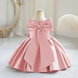 Stumbling toddler girl over 1 year old with a big bow dress, pink baby girl washing dress, formal Christmas children's clothing