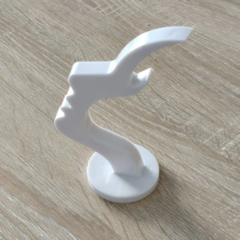 Sculpturalny stojak na okulary: elegancki kształt siluety twarzy zapewniający bezpieczeństwo okularów i stylowy, minimalistyczny profil twarzy jako podstawka pod okulary.