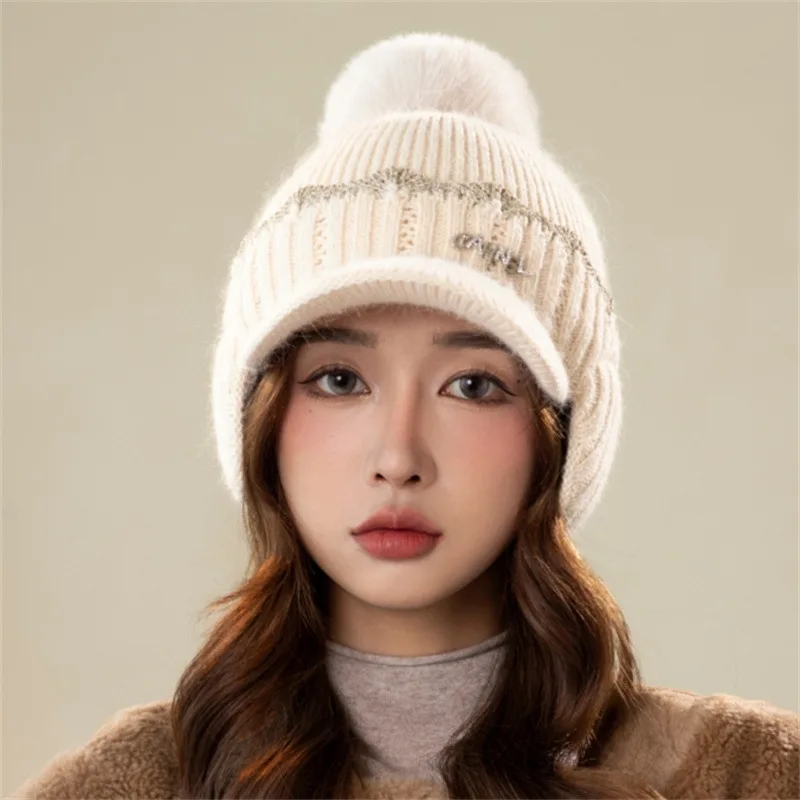 Korean style knitted hat for women. Warm in winter with rabbit fur ear flaps. Fashionable, thickened and has a pompom.