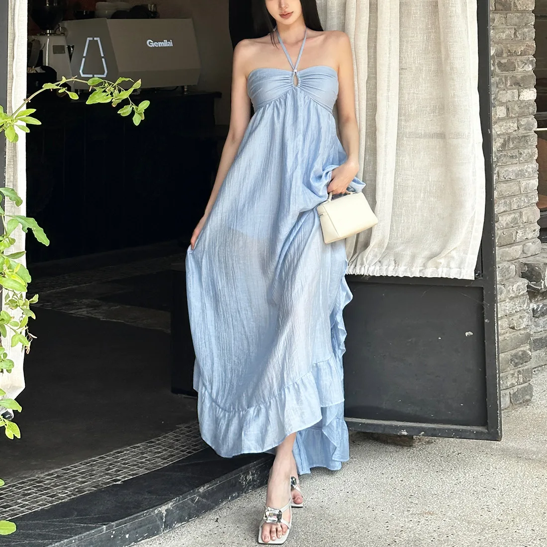 Ein neues Frühjahr/Sommer 2025, elegantes und schlichtes, einfarbiges Damenkleid mit plissiertem Saum, auffälliges Neckholder-Kleid für den Urlaub