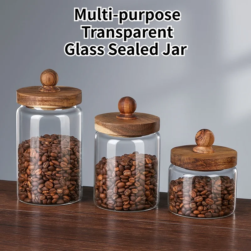 Drie glazen voorraadpotten met houten deksel gevuld met koffiebonen